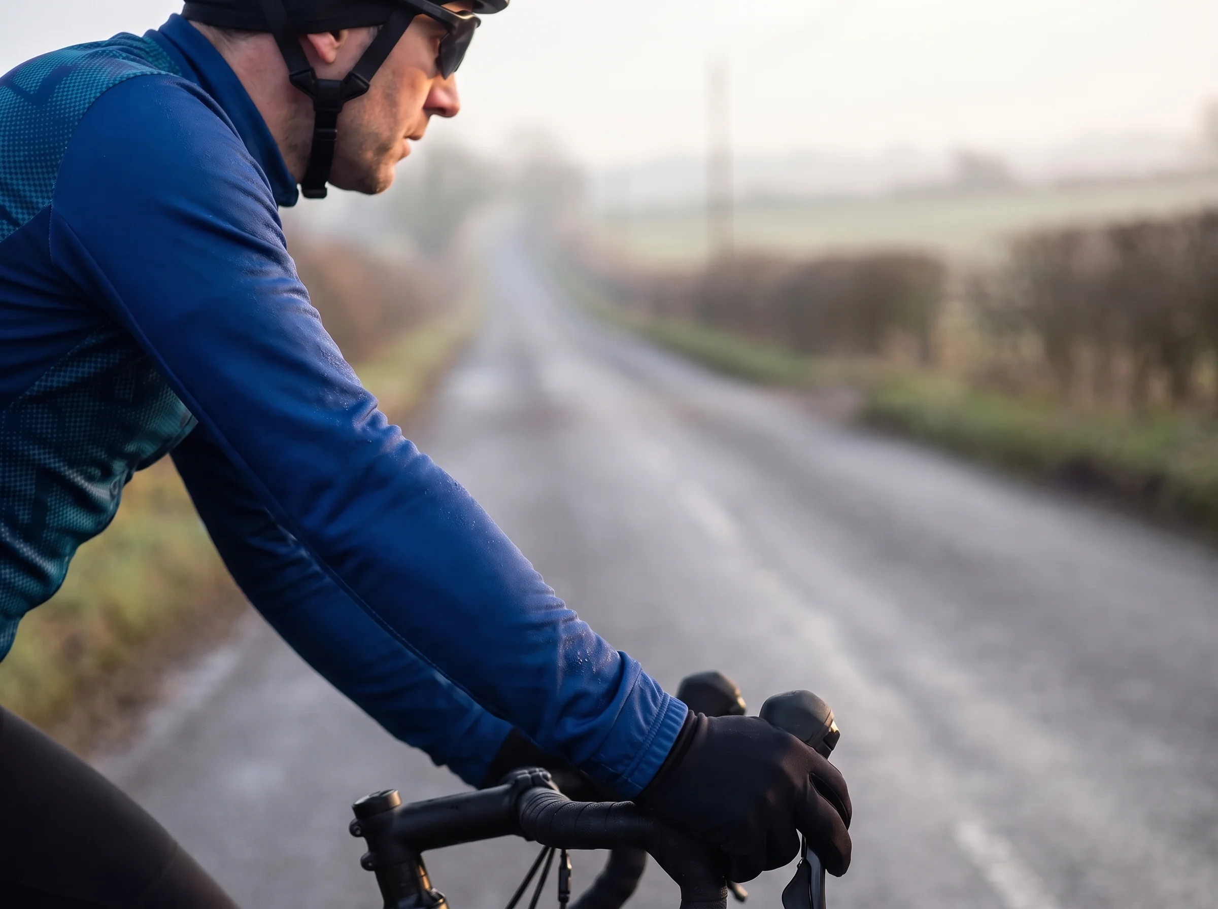 A race jersey sleeve on a rider's arm on the hoods